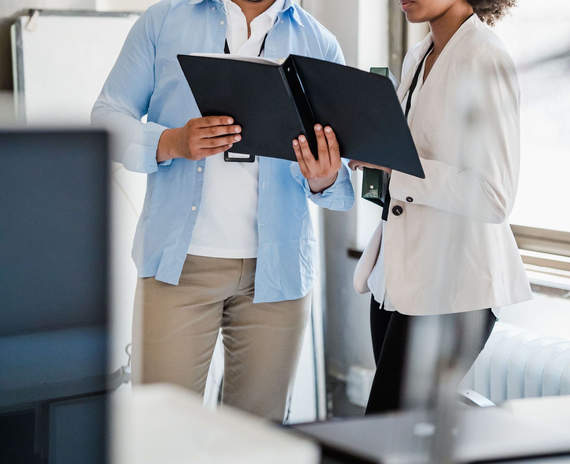 Diverse team collaborating in a bright modern office environment, reviewing files.